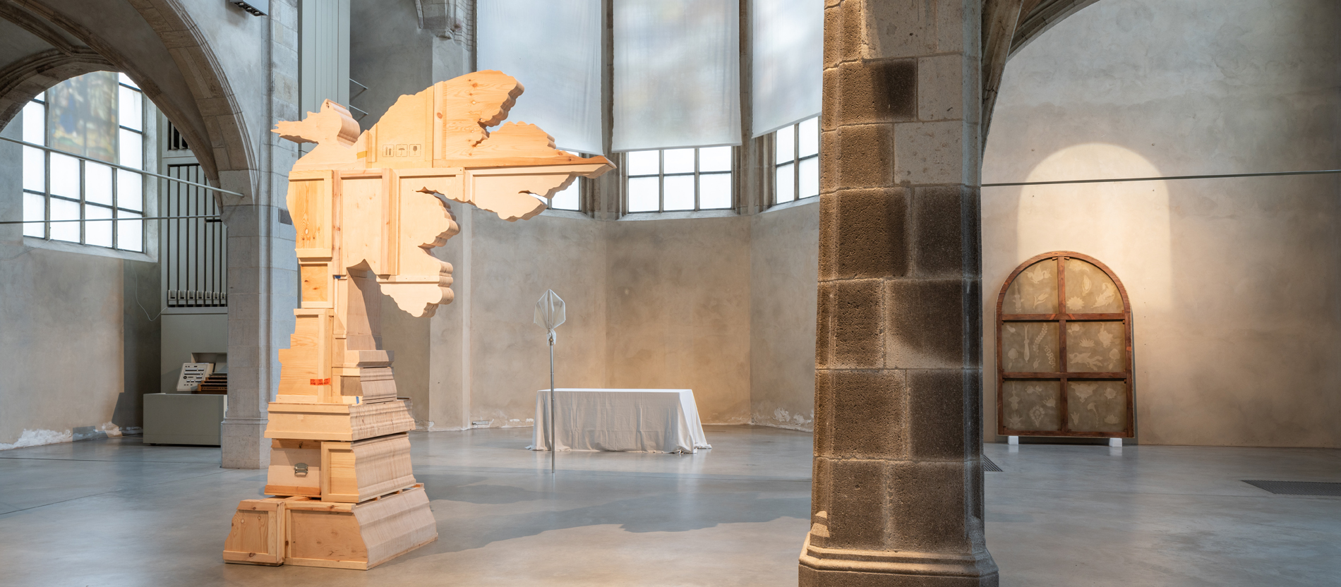 Eine Holzskulptur steht im ansonsten fast leeren Kirchenraum von St. Peter in Köln