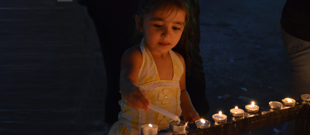 Irakisches Flüchtlingsmädchen beim Entzünden einer Kerze in einer Kirche