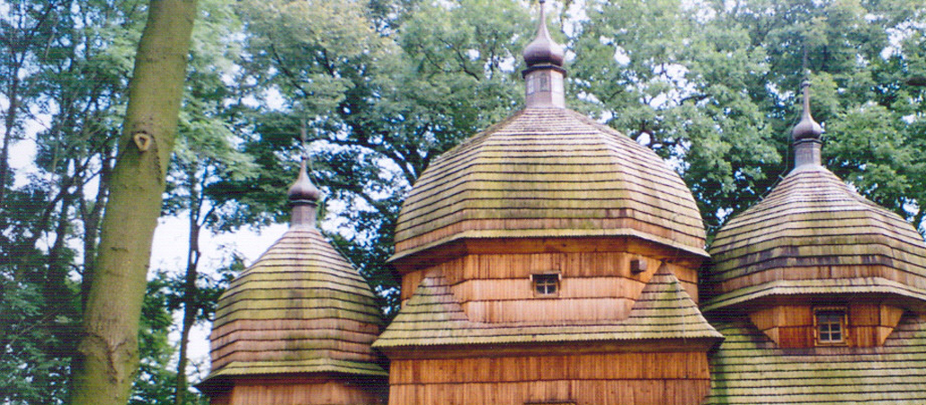 Eine Holzkirche steht in einem Wald.