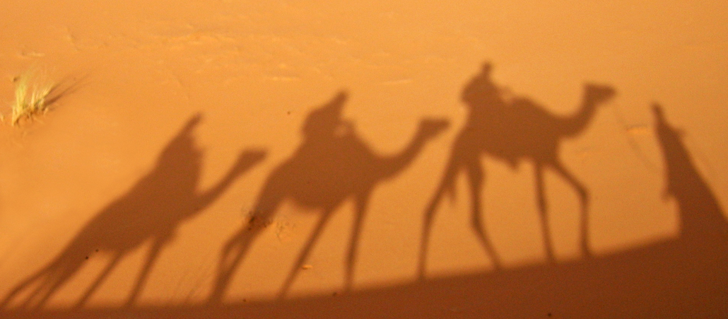 Schatten von Kamelreitern in der Wüste.