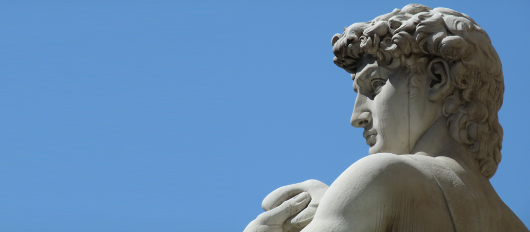 Kopf und Schultern der berühmten Darstellung des David von Michelangelo vor blauem Himmel.