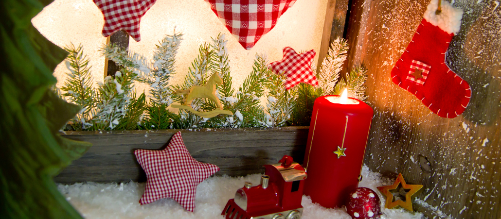 Erleuchtetes Fenster mit Weihnachtsdeko.