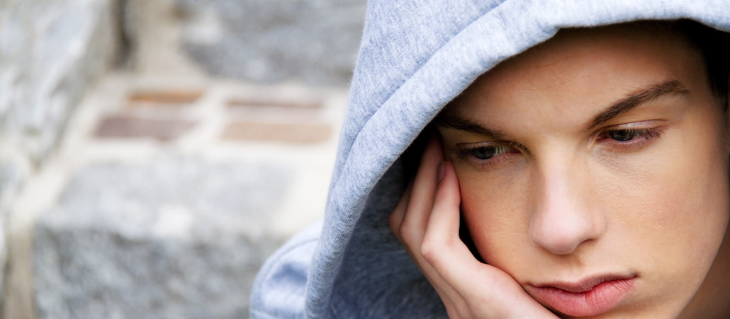 Jugendlicher mit Kapuze, Detailaufnahme vom traurigen Gesicht