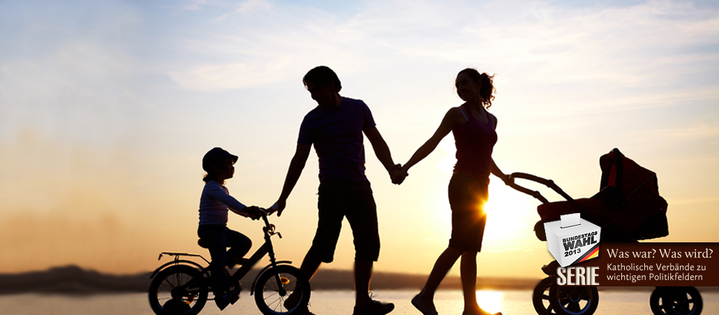 Familie im Gegenlicht eines Sonnenuntergangs am See.
