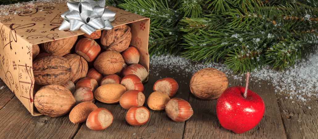 Umgefallene Papiertüte aus der Nüsse quellen unterm Weihnachtsbaum