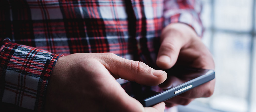 Ein Mann schaut auf ein Smartphone.