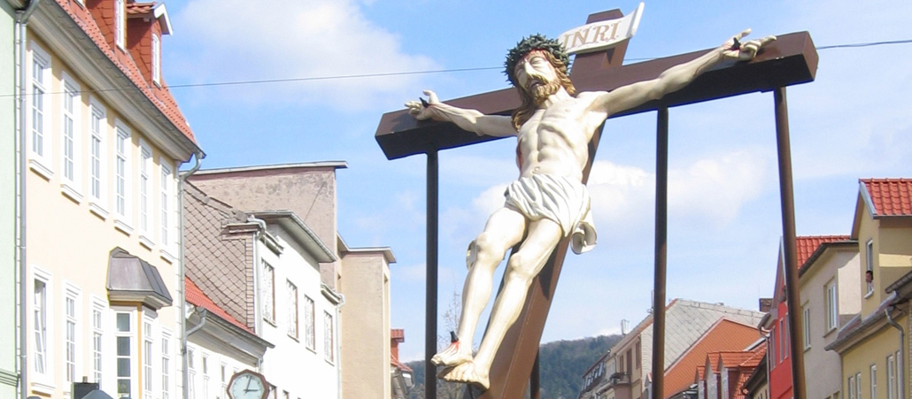 Mehrere Männer tragen eine Jesus-Figur durch die Straßen einer Stadt