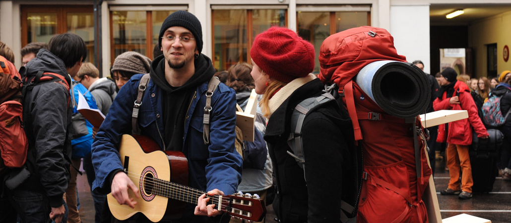 Ein Jugendlicher spielt trotz des starken Regens Gitarre.