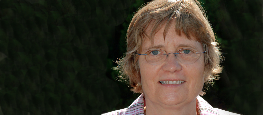 Ältere Frau mit Brille und kurzen Haaren