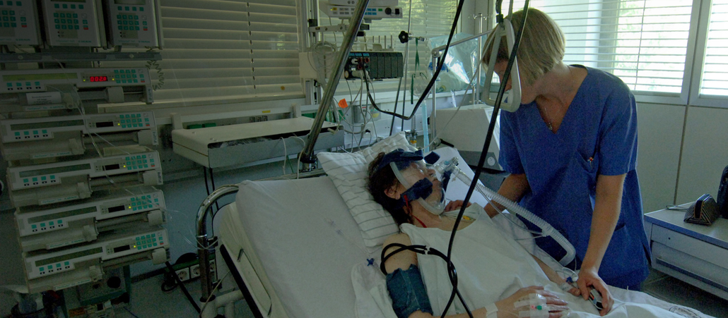 Eine Krankenpflegerin versorgt einen Kranken.