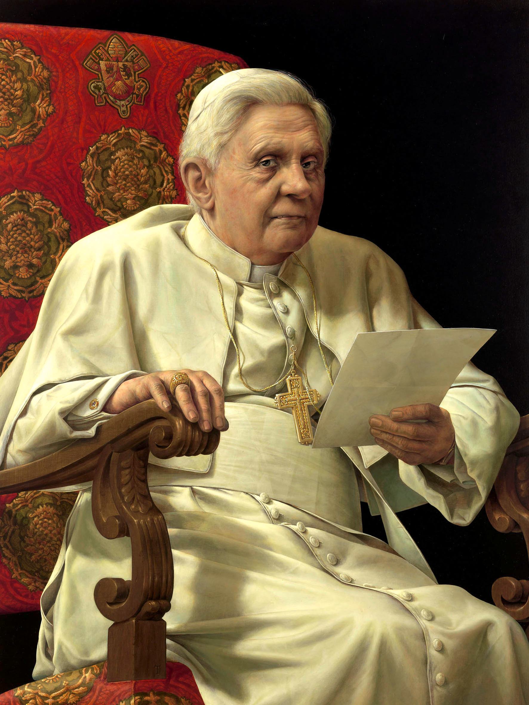Benedikt XVI. sitzend, ein Papier in der Hand