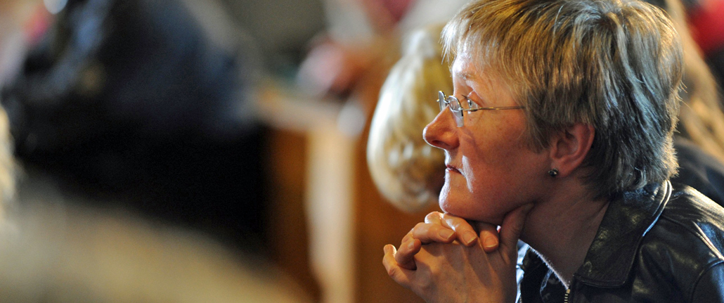 Eine Frau betet in einer Kirche.