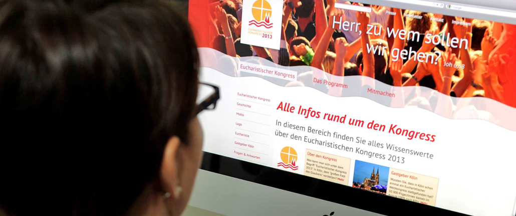 Eine junge Frau betrachtet die Webseite des Eucharistischen Kongresses.