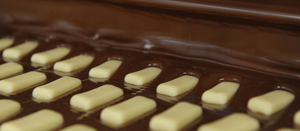 Die kleinen Marzipanbrote tauchen in Schokolade ein.