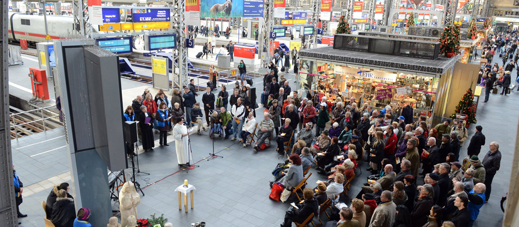 Eine Menschenmenge feiert Gottesdienst am Frankfurter Hauptbahnhof