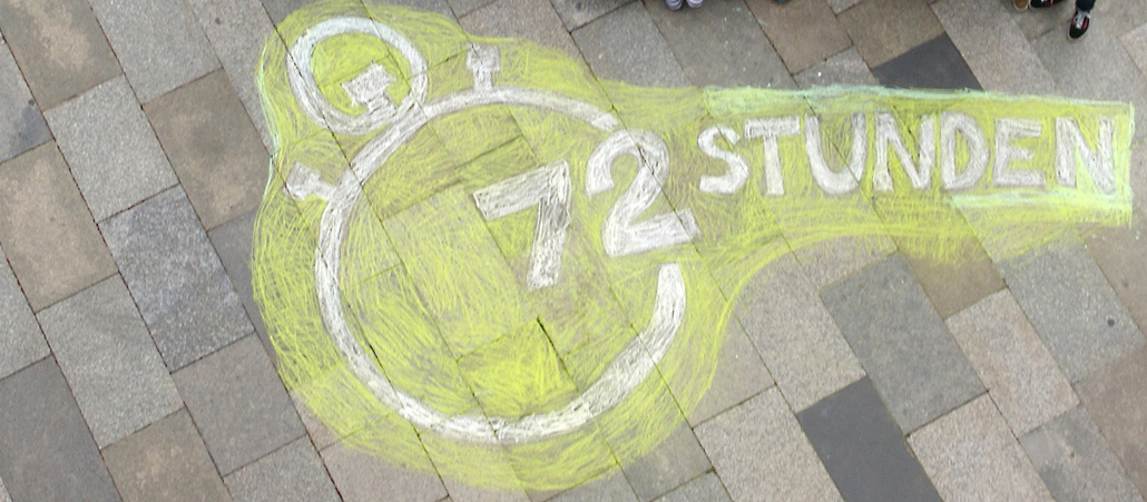 Ein Kreidebild des Logos des 72-Stunden-Aktion vor dem Kölner Dom.