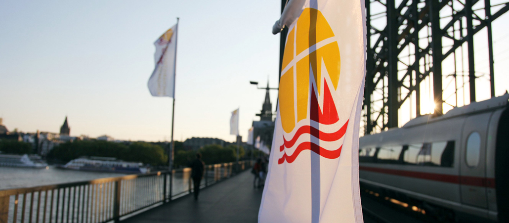 Flagge des Eucharistischen Kongresses in der Abendsonne auf der Hohenzollernbrücke.