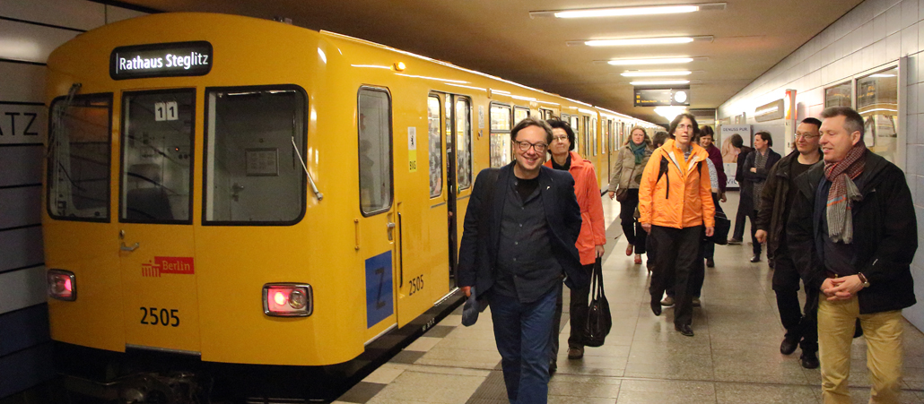 Eine U-Bahn der LInie 19 (am linken Bildrand, gelb) und dutzende Passagiere, die aus dem Zug zu den Ausgängen strömen.