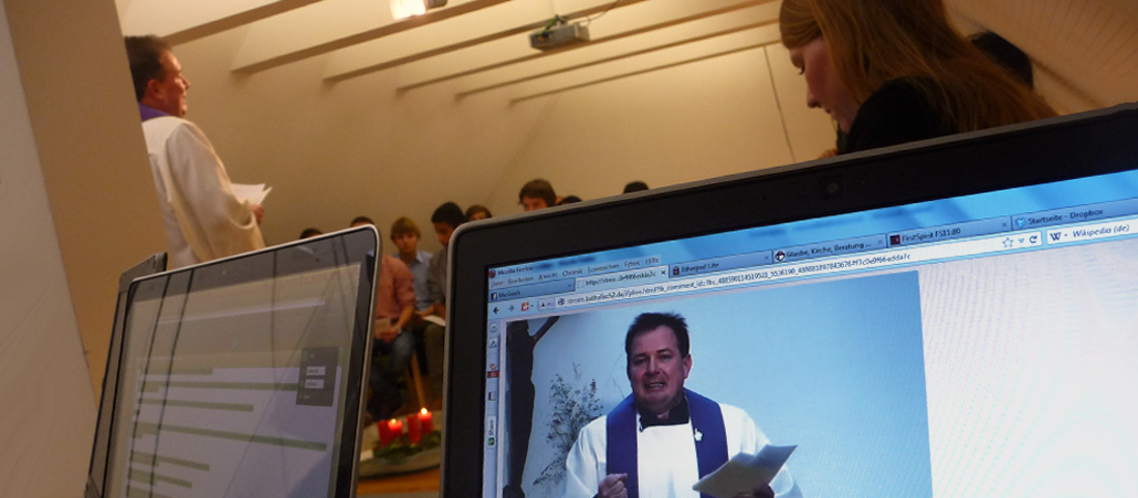 Im Vordergrund ist der Pfarrer auf einem Computerbildschirm zu sehen im Hintergrund life.
