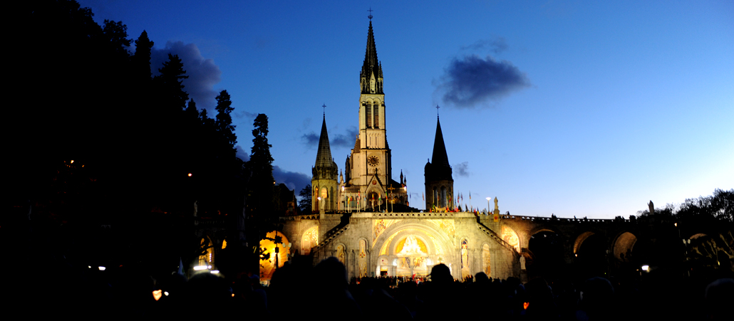 Die beleuchtete Kathedrale hebt sich von dem tiefblauen Abendhimmel ab.