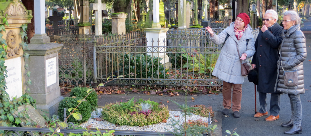 Unterwegs mit Interessenten: Grabpatin Eva Hüttenhain führt ein Ehepaar über den Alten Friedhof in Bonn.
