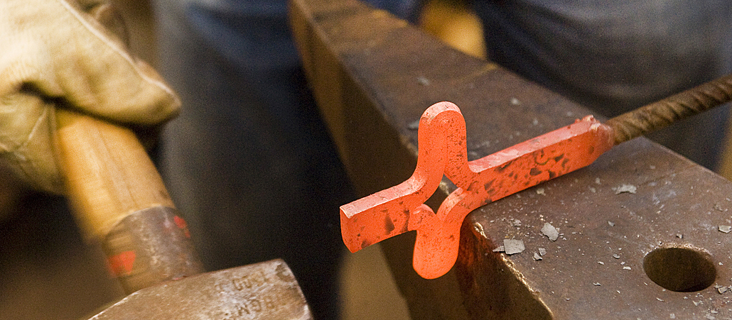 Aus Eisen wird ein Kreuz geformt.