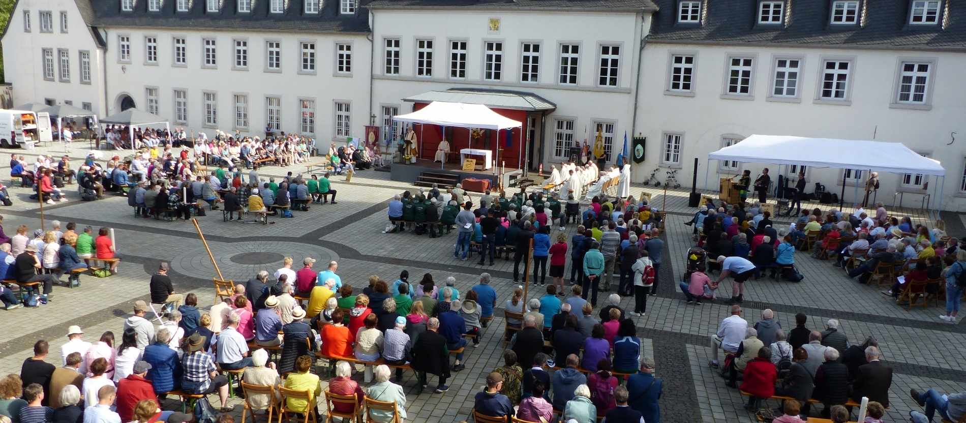 Viele Pilger treffen sich für einen Gottesdienst unter freiem Himmel. 