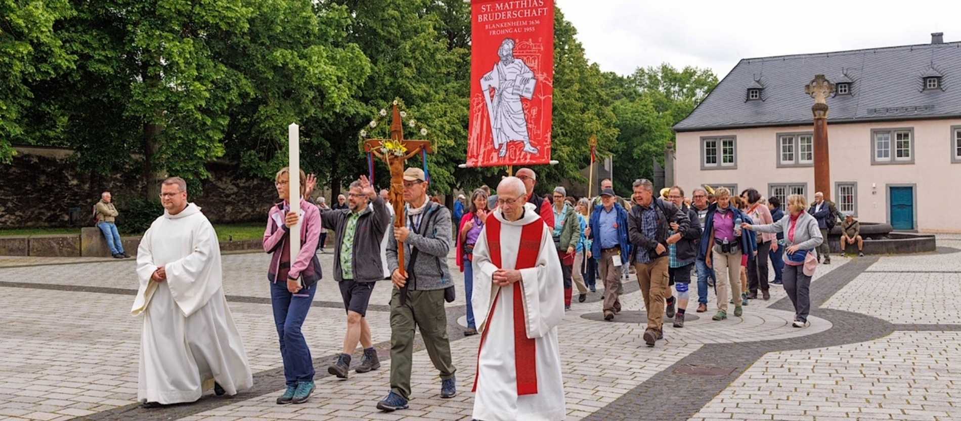 Eine Gruppe läuft mit einem Kreuz. 