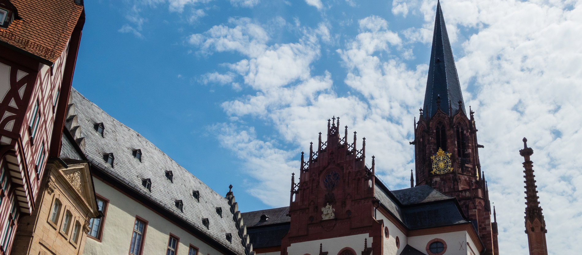 Die gotische Fassade und der Turm der Stiftsbasilika in Aschaffenburg aus rotem Sandstein.