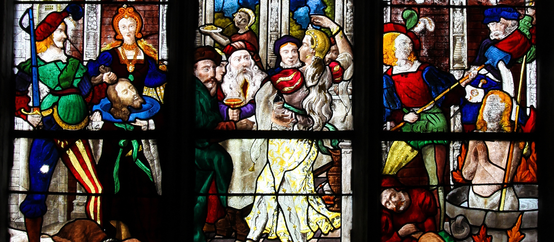 Ein Kirchenfenster zeigt die Enthauptung von Johannes dem Täufer und den Tanz der Salome