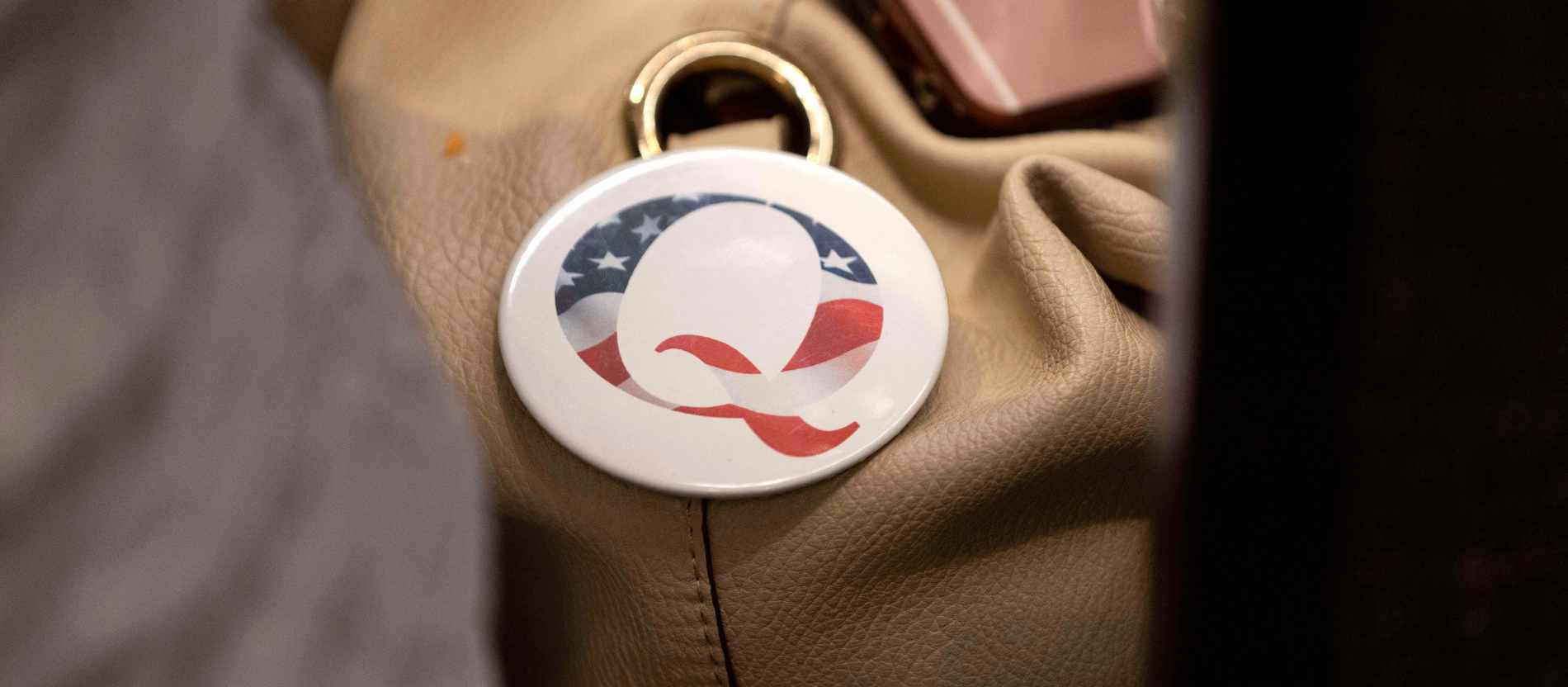 Ein Anstecker der QAnon-Verschwörungstheorie