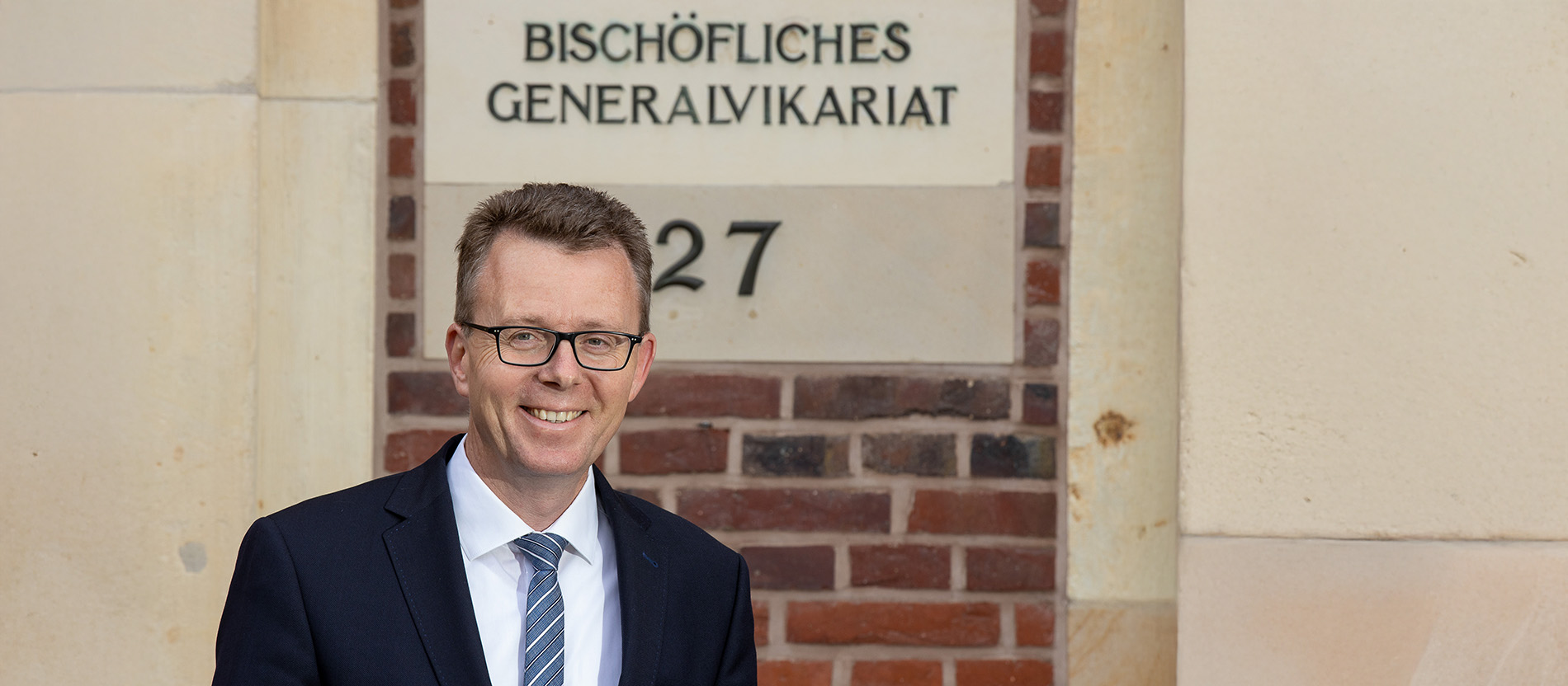 Foto von Frank Vormweg vor dem Eingang zum Münsteraner Generalvikariat