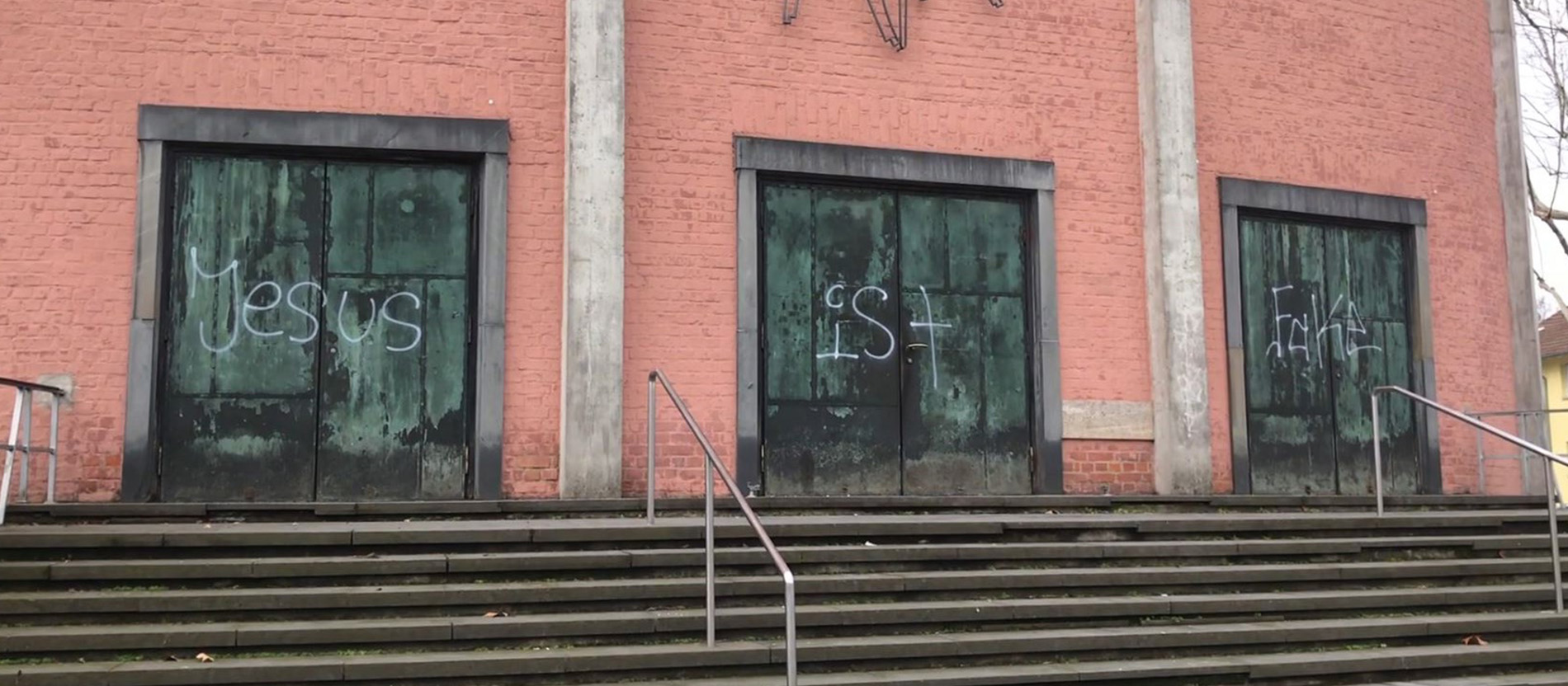 Drei Kirchentüren mit Graffitis darauf