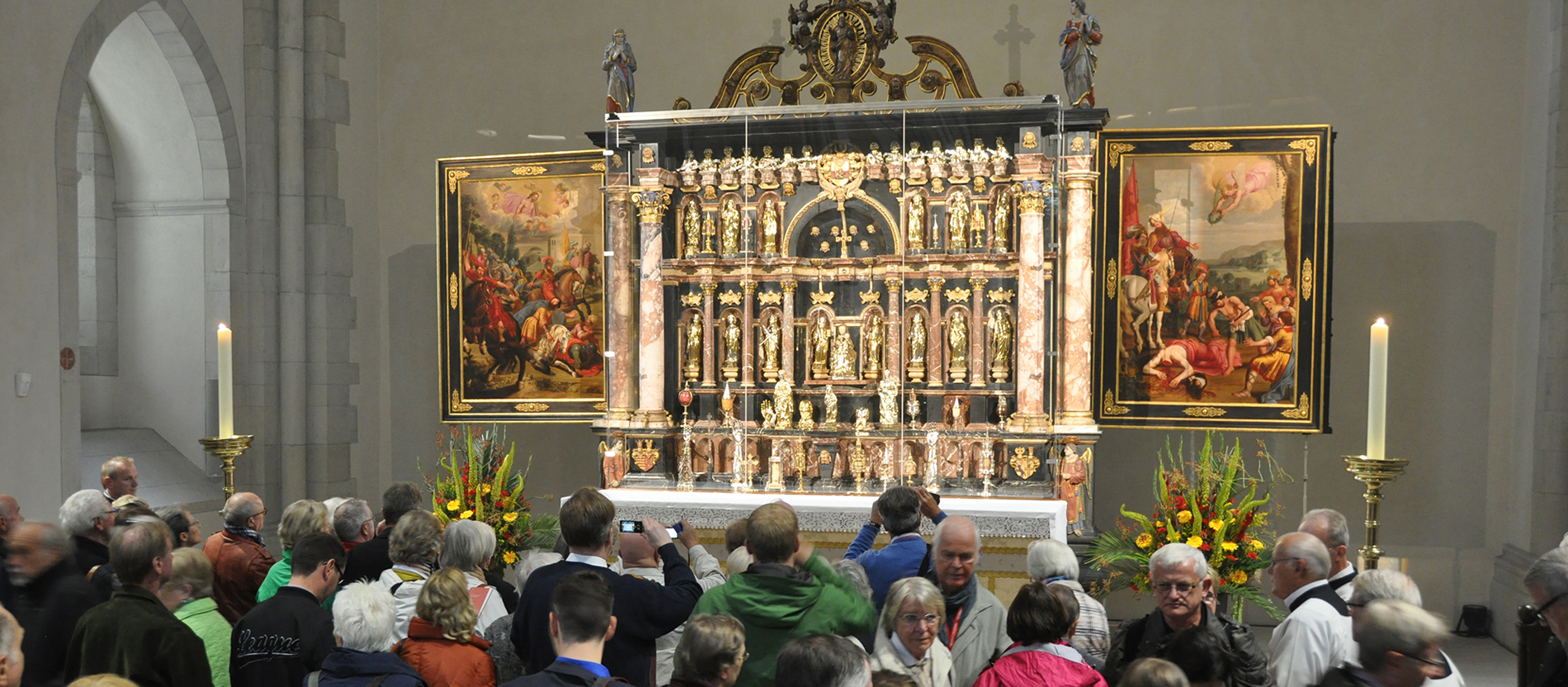 Menschen stehen vor einem Altar mit Reliquien