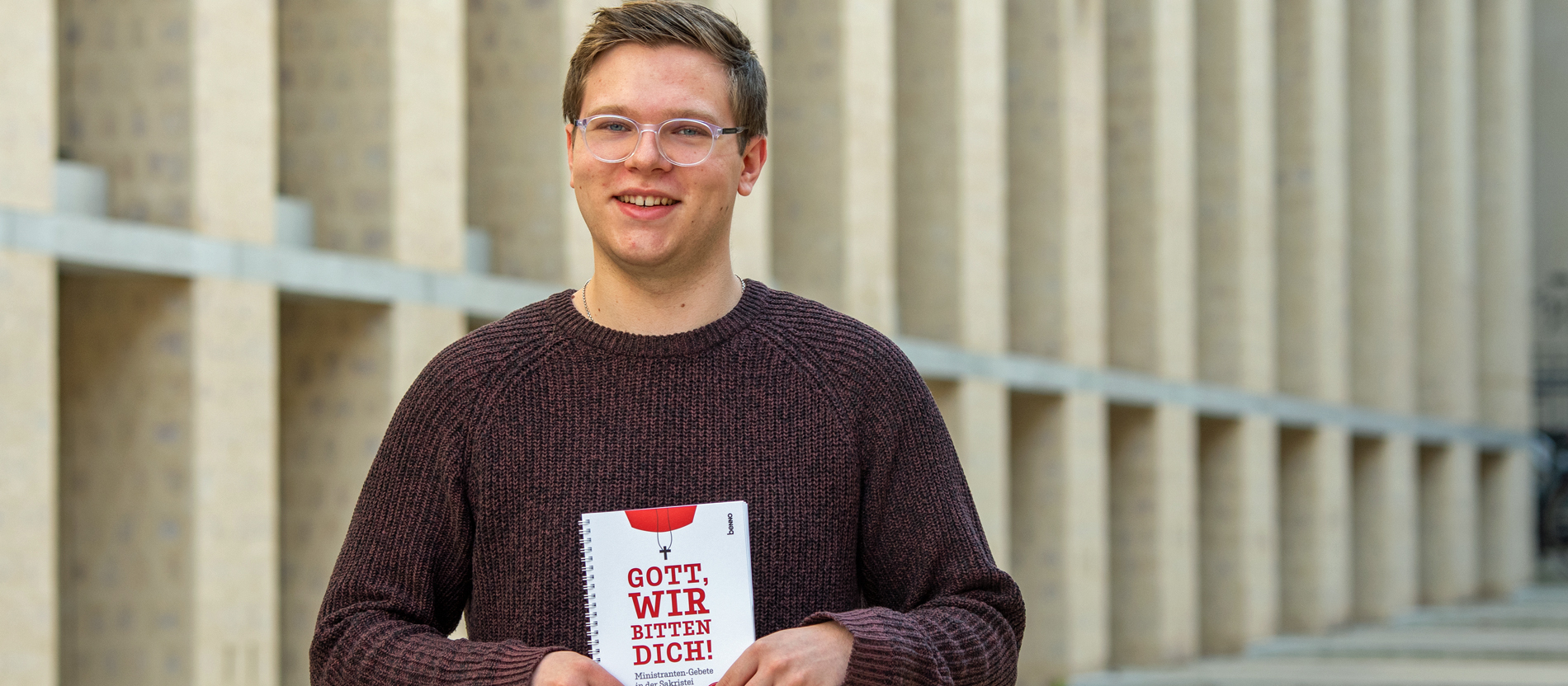 Janis Jaspers hält sein Buch mit Messdiener-Gebeten für die Sakristei