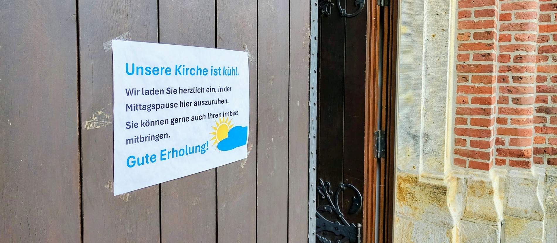 Ein Zettel an der Kirchentür lädt Menschen zur Abkühlung ein