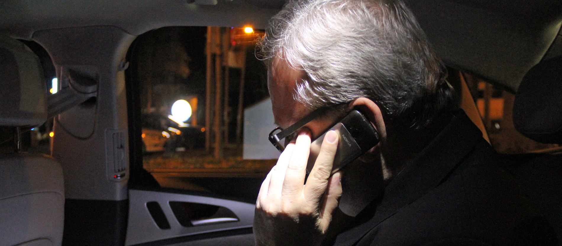 Bischof Bode telefoniert im Auto, es ist dunkel.