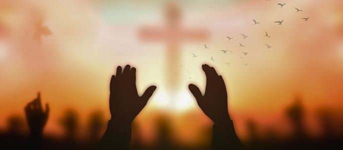 Hände und ein Kreuz