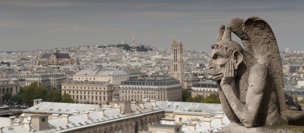 Wasserspeier (Gargoyle) auf der Kathedrale Notre Dame in Paris und die Basilika Sacre Coeur im Hintergrund.