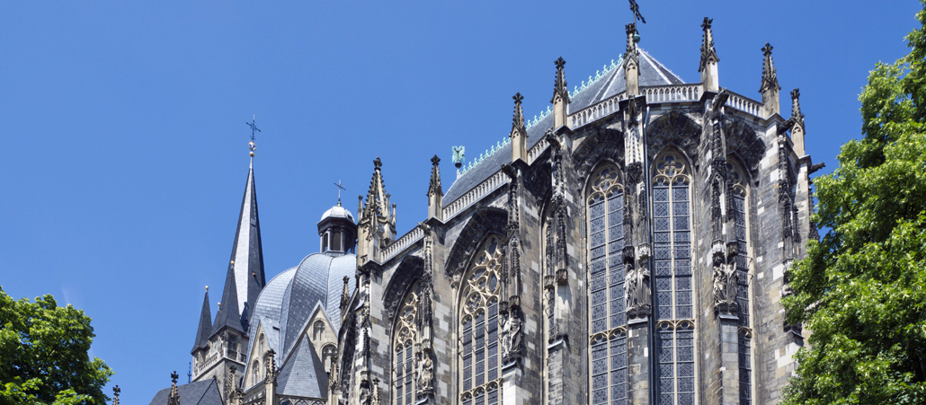 Dem Aachener Dom wurde 1978 als erstem deutschen Kulturdenkmal der Titel als Unesco-Weltkulturerbe verliehen. Erbaut wurde der Dom, der der Gottesmutter Maria geweiht ist, um 800 unter Karl dem Großen. Er gilt als weltweit bedeutsamstes architektonisches Beispiel der karolingischen Renaissance. Das Zentrum des Doms bildet die Pfalzkapelle. Sie war das erste gewölbte Gebäude nördlich der Alpen und ist eine Mischung  von Bautraditionen der klassischen Antike und der byzantinischen Architektur.