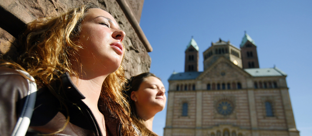 Frauen genießen die Sonne vor dem Speyerer Kaiserdom.