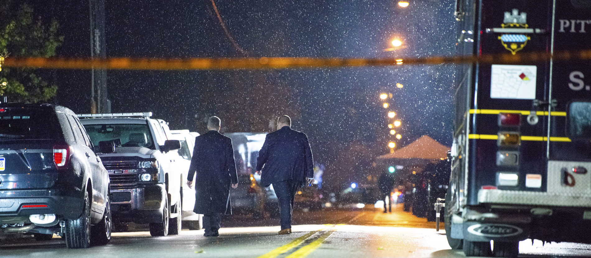 Männer in Anzügen laufen durch Regen