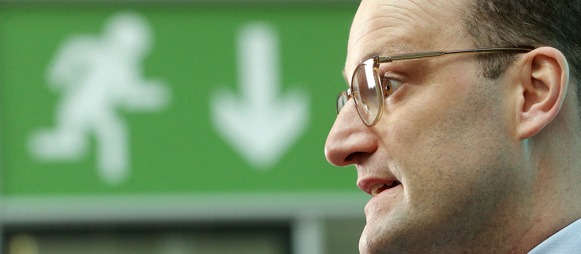 Jens Spahn (CDU) vor einem Notausgang-Schild