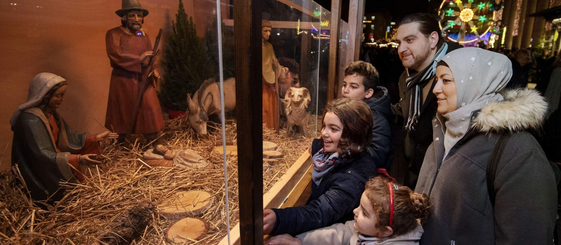 Eine muslimische Familie besucht einen Weihnachtsmarkt. 