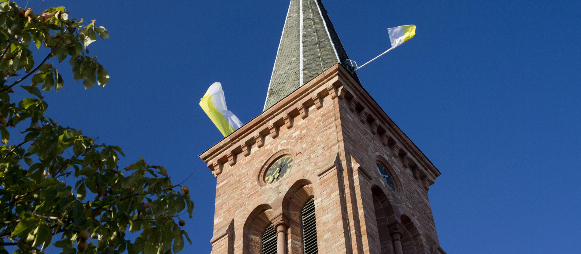 Fahnen wehen auf einem Kirchturm
