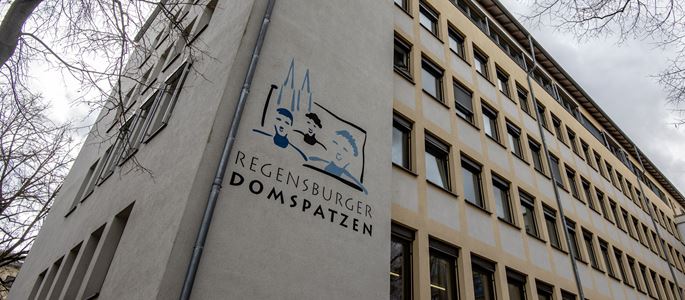 Das Logo der Regensburger Domspatzen vor dem Schulgebäude.