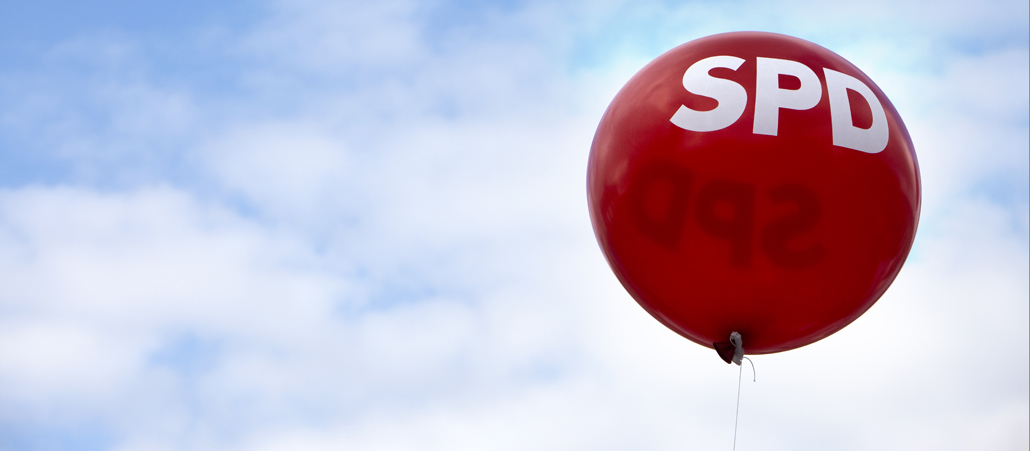 Ein roter SPD-Luftballon schwebt vor blauem Himmel.