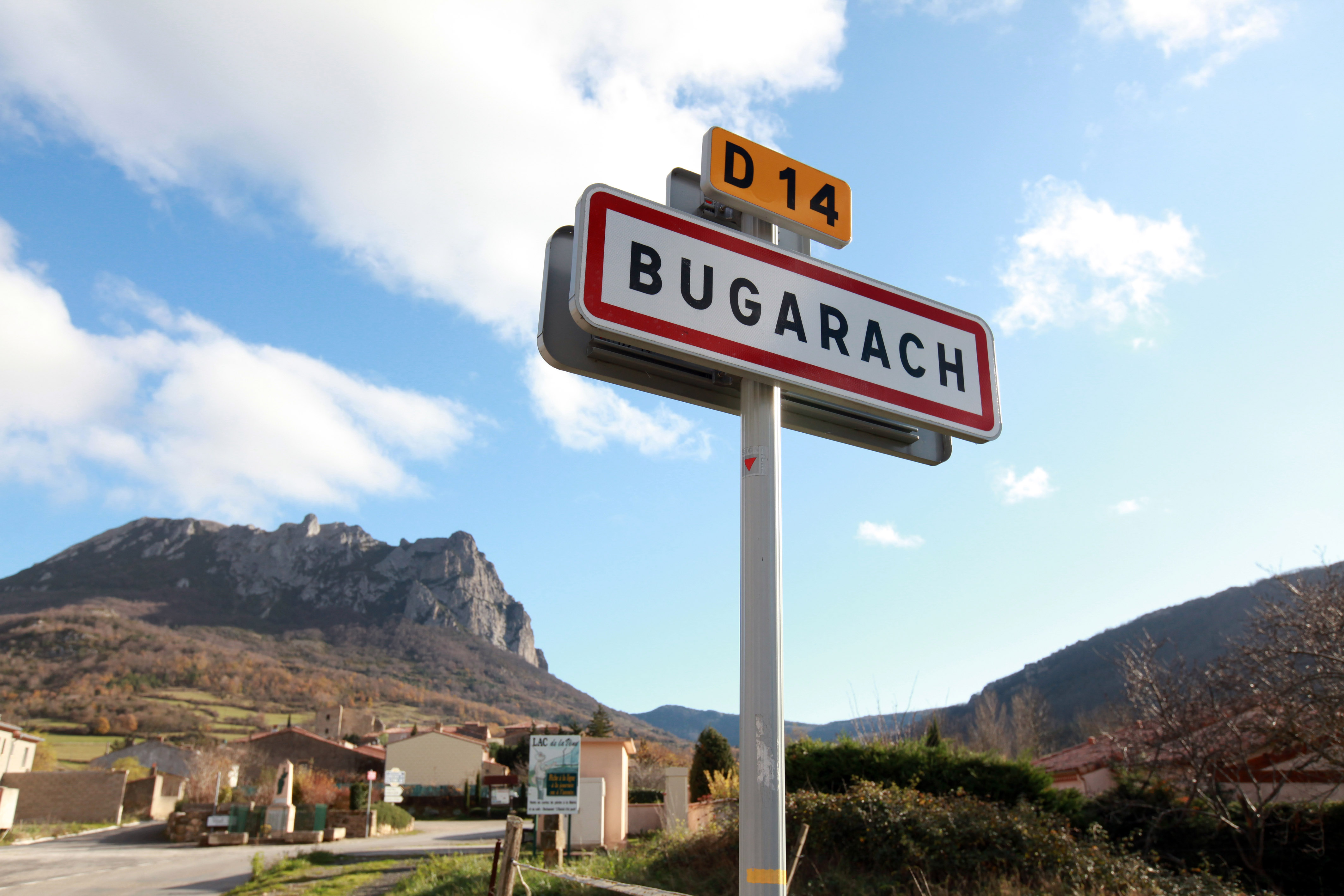 Ein Ortschild und eine Pyrinäen-Landschaft im Hintergrund