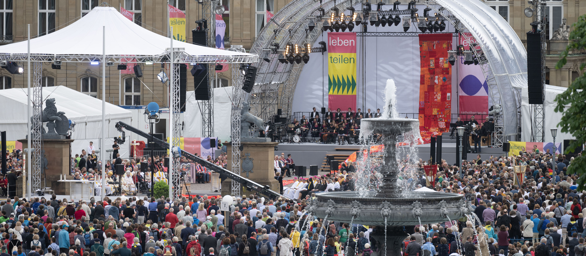 Menschen nehmen an der Eucharistiefeier des Katholikentags teil.
