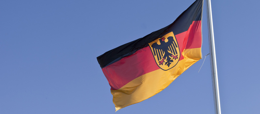 Eine deutsche Flagge vor blauem Himmel.